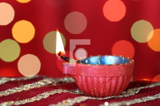 Diwali Diya with blurred festive lights in the background
