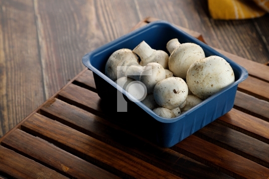 Fresh Uncooked Organic Button Mushrooms in Retail Plastic Box