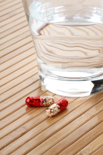 Glass of Water and Medicine Capsules