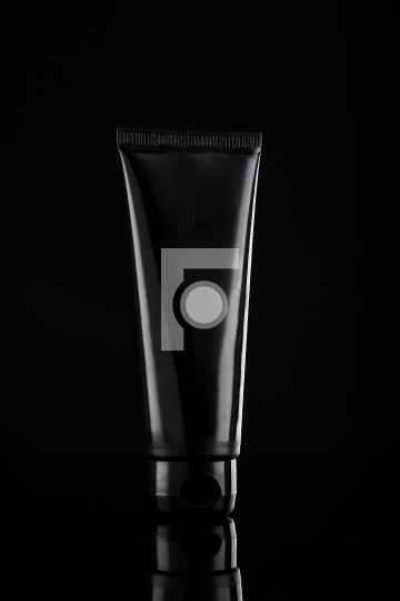 Glossy Black Product Cosmetic Tube on Black Background
