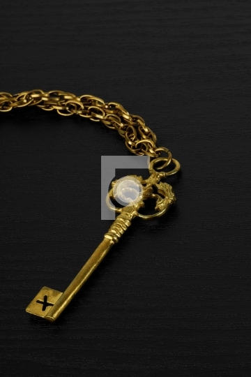 Golden Antique Key on black wooden background