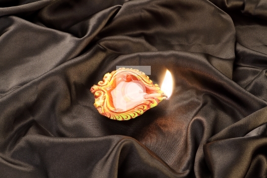 Handmade Diwali Clay Lamp on Black Satin Background