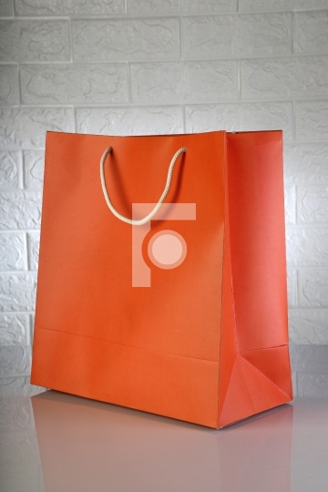 Orange Paper Shopping Bag on White Brick Background for Mockups
