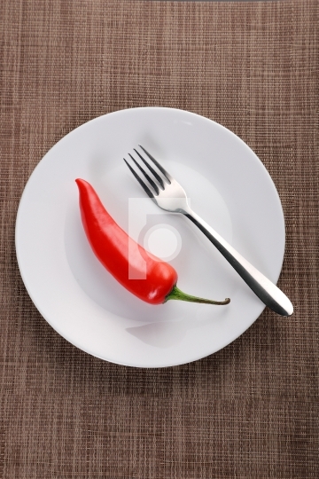 Red chiili on a plate with a fork 
