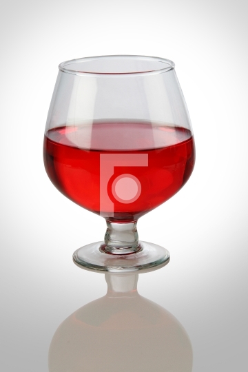 Red Wine Glass on White Reflective Background