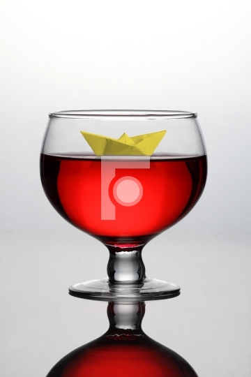 Red Wine Glass with a Paper Boat - Concept