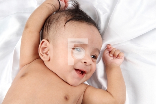Smiling Baby on white satin background