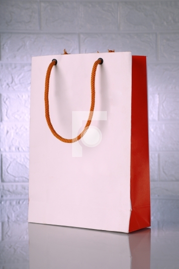 White And Orange Paper Shopping Bag on a Brick Wall Background